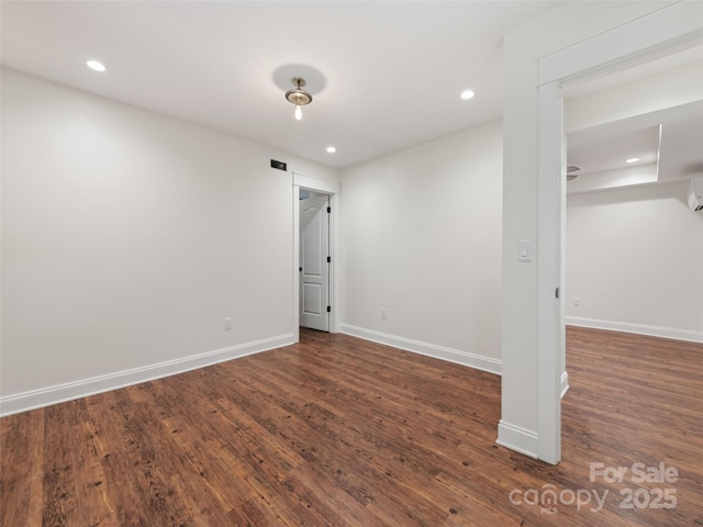 unfurnished room featuring dark hardwood / wood-style floors and a wall unit AC