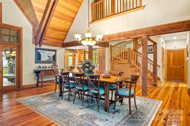 dining space with a notable chandelier, light hardwood / wood-style floors, high vaulted ceiling, and a healthy amount of sunlight