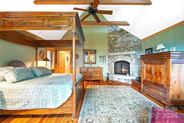 bedroom with high vaulted ceiling, a stone fireplace, beam ceiling, ceiling fan, and hardwood / wood-style flooring