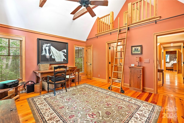 office space with ceiling fan, hardwood / wood-style floors, and high vaulted ceiling