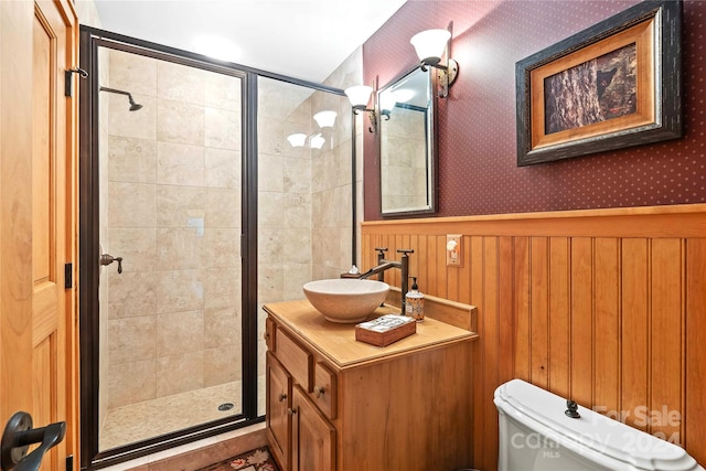 bathroom with a shower with shower door, vanity, and toilet