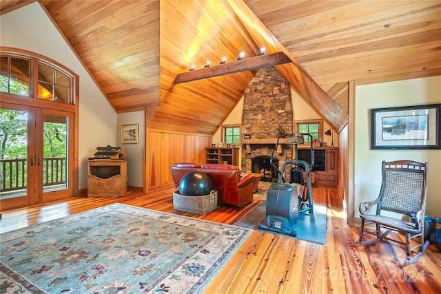 living room featuring a stone fireplace, wood ceiling, and hardwood / wood-style floors