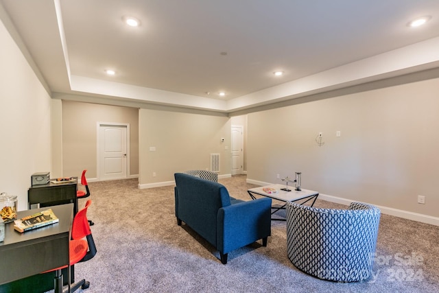 carpeted living room with a raised ceiling