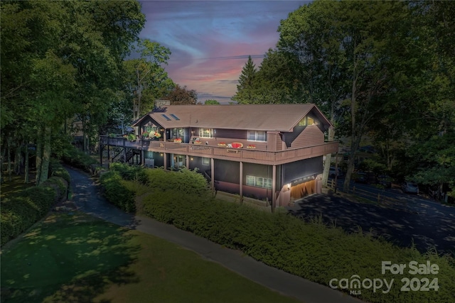 back house at dusk featuring a balcony