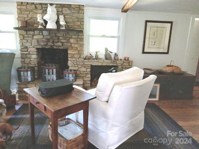 living room featuring a fireplace, beam ceiling, and hardwood / wood-style flooring