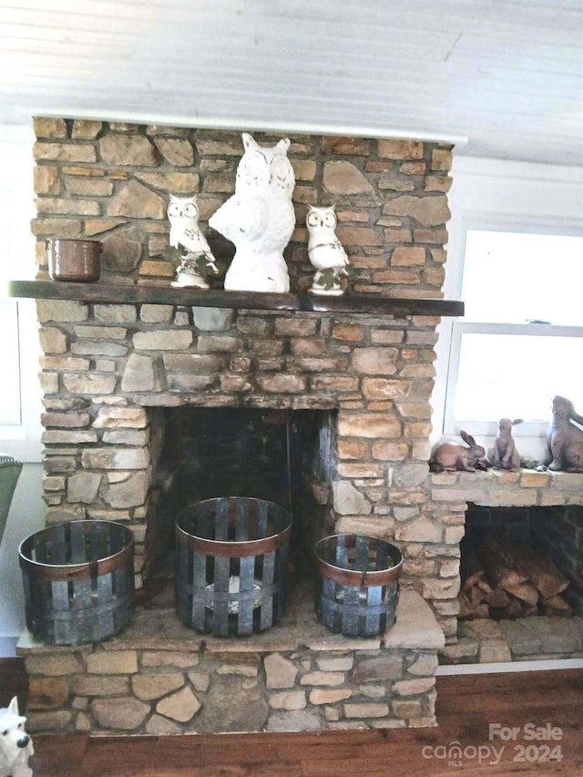 interior details with a stone fireplace and hardwood / wood-style floors