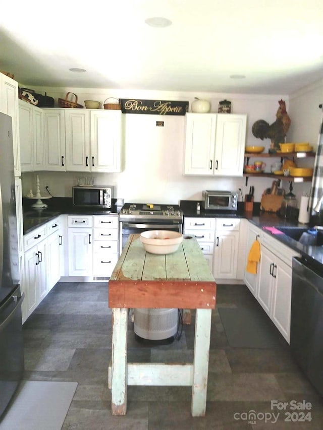 kitchen featuring dishwasher, electric range, sink, white cabinetry, and refrigerator