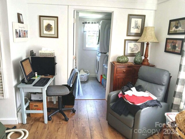 office space with stacked washing maching and dryer and hardwood / wood-style floors