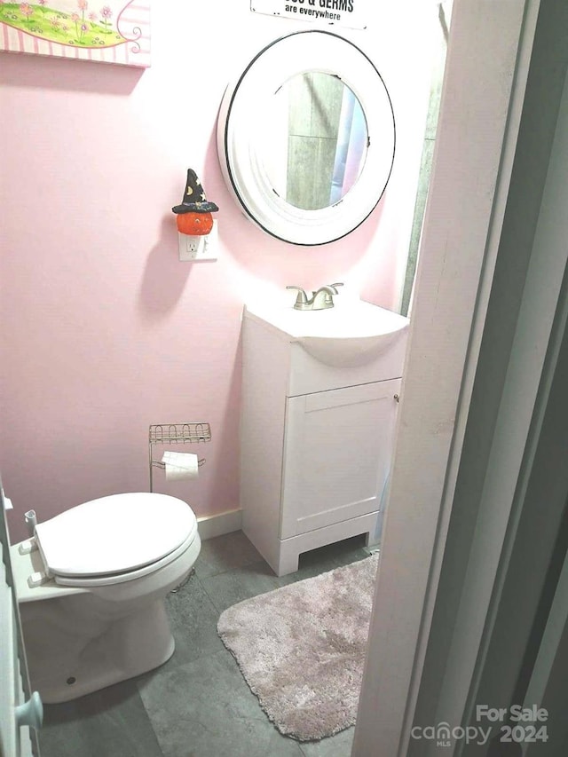 bathroom with vanity, toilet, and tile patterned floors