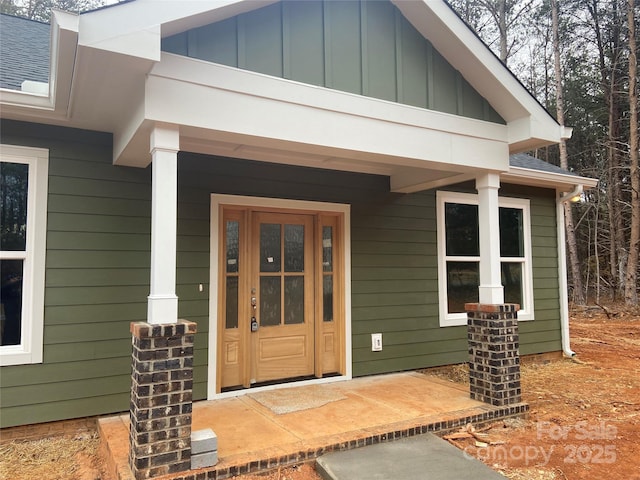 view of exterior entry featuring covered porch