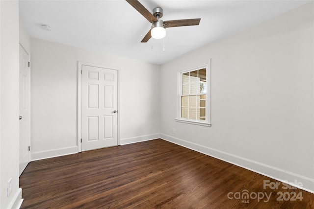 spare room featuring dark wood-type flooring and ceiling fan