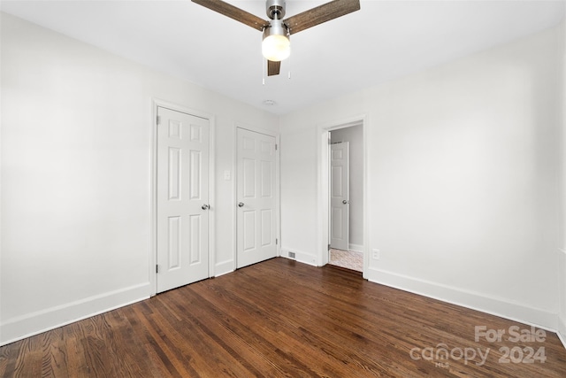 unfurnished bedroom featuring ceiling fan and dark wood-type flooring