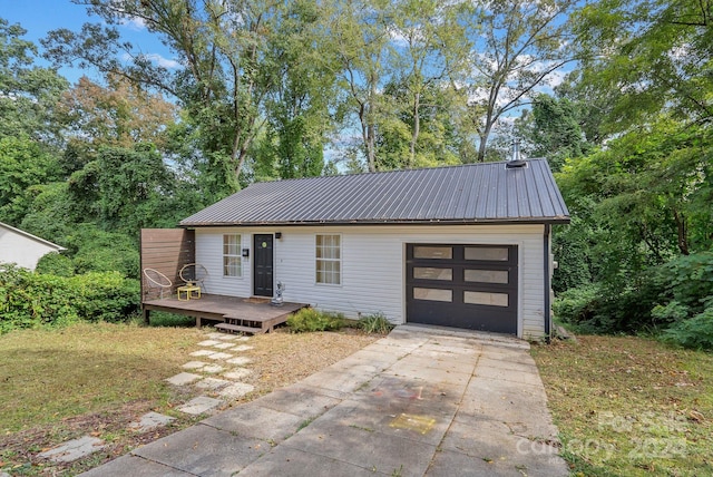 view of front of property with a deck, a garage, and a front lawn