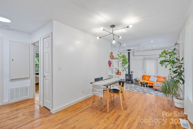 dining area featuring ceiling fan with notable chandelier and light hardwood / wood-style flooring