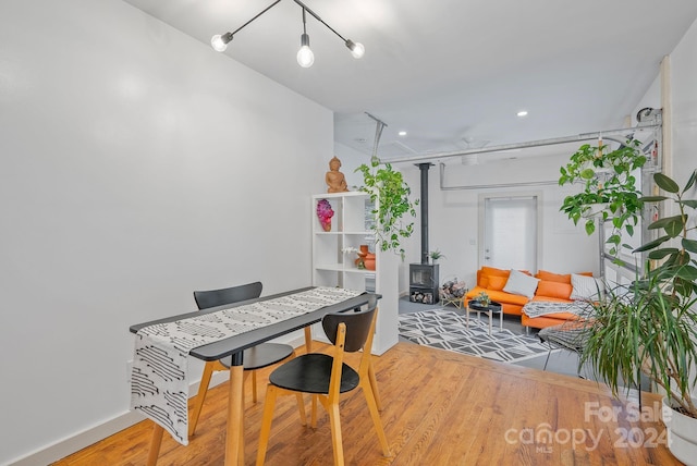 dining room with a wood stove and wood-type flooring