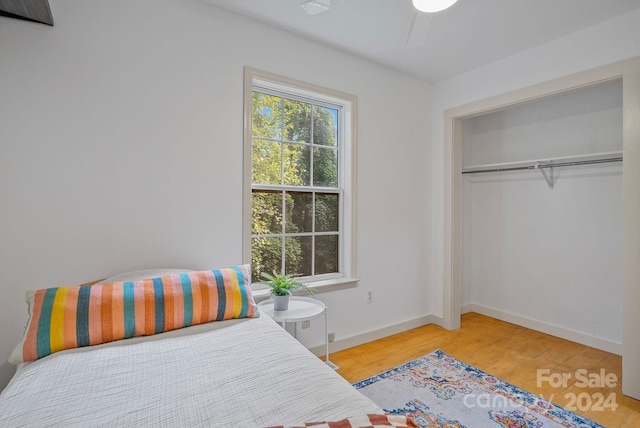 bedroom featuring ceiling fan, a closet, and hardwood / wood-style flooring