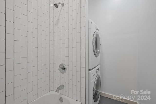 interior space with tiled shower / bath and stacked washing maching and dryer