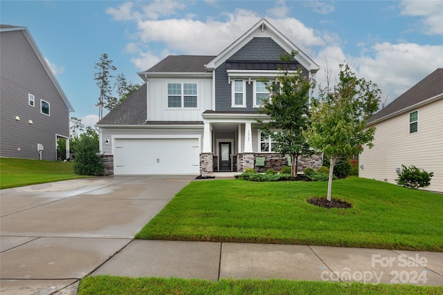 craftsman inspired home featuring a garage, a front lawn, and covered porch