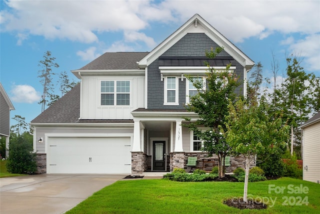 craftsman house featuring a garage and a front lawn