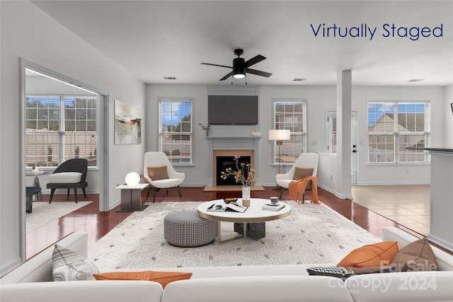 living room with ceiling fan, plenty of natural light, and dark wood-type flooring