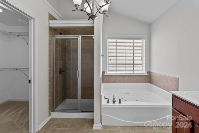 bathroom featuring an inviting chandelier, separate shower and tub, tile patterned floors, vaulted ceiling, and vanity