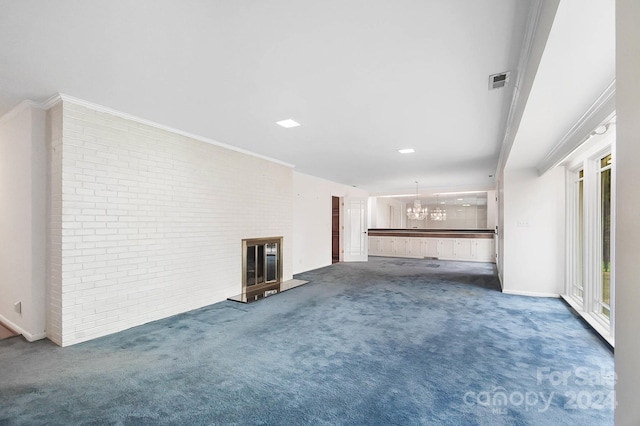 unfurnished living room with brick wall, a notable chandelier, crown molding, and carpet