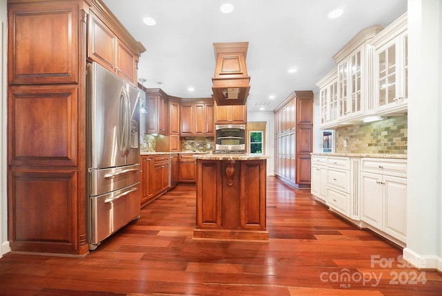 kitchen with backsplash, a kitchen island, dark hardwood / wood-style flooring, and stainless steel appliances