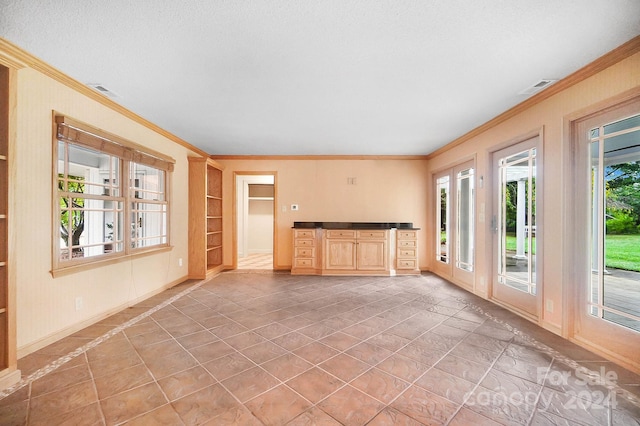 unfurnished living room with a textured ceiling, ornamental molding, and plenty of natural light