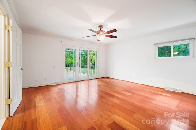 spare room featuring wood-type flooring, crown molding, and ceiling fan