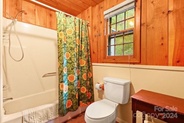 bathroom featuring shower / bath combo with shower curtain, toilet, wooden walls, and wood ceiling