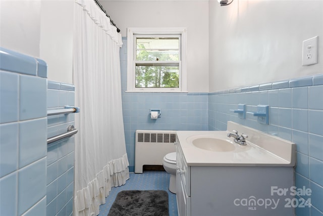 bathroom with vanity, radiator heating unit, curtained shower, tile walls, and toilet