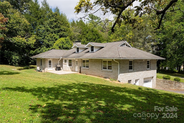 back of house featuring a garage, a yard, and a patio area