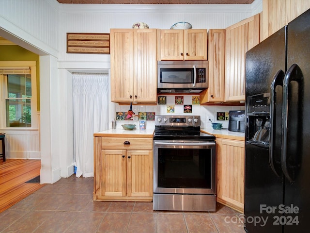 kitchen featuring stainless steel appliances, tile patterned flooring, light brown cabinets, and crown molding