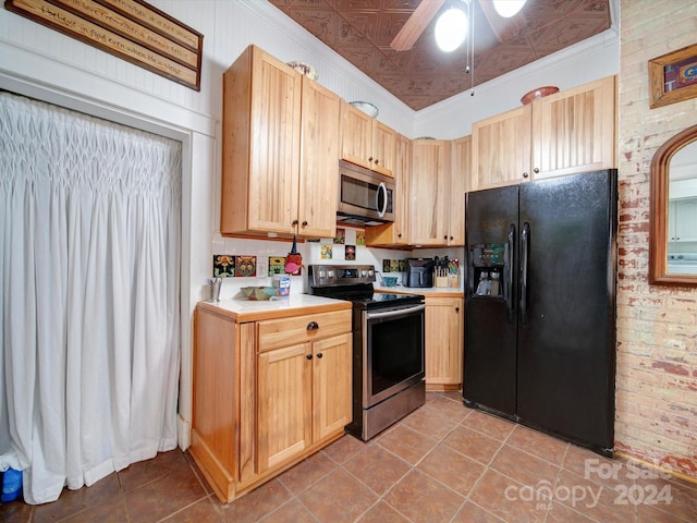 kitchen with appliances with stainless steel finishes, light tile patterned flooring, brick wall, ceiling fan, and ornamental molding