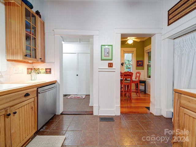 kitchen featuring backsplash, stainless steel dishwasher, sink, and ceiling fan