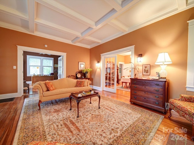 living room with coffered ceiling, beamed ceiling, hardwood / wood-style flooring, and crown molding