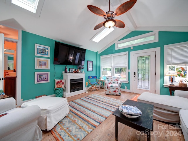 living room with a wealth of natural light, light hardwood / wood-style floors, and ceiling fan