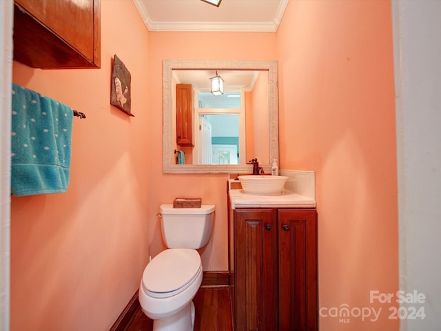 bathroom featuring ornamental molding, vanity, hardwood / wood-style floors, and toilet