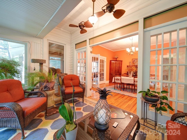 sunroom with ceiling fan with notable chandelier