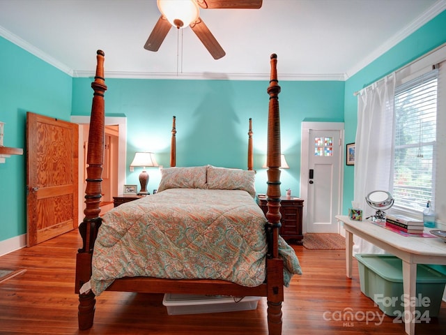 bedroom featuring wood-type flooring, ornamental molding, multiple windows, and ceiling fan