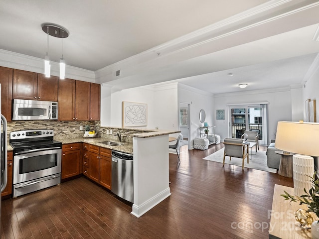 kitchen featuring dark wood-type flooring, crown molding, appliances with stainless steel finishes, light stone counters, and kitchen peninsula