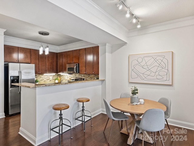 kitchen with backsplash, hanging light fixtures, dark hardwood / wood-style floors, kitchen peninsula, and stainless steel appliances