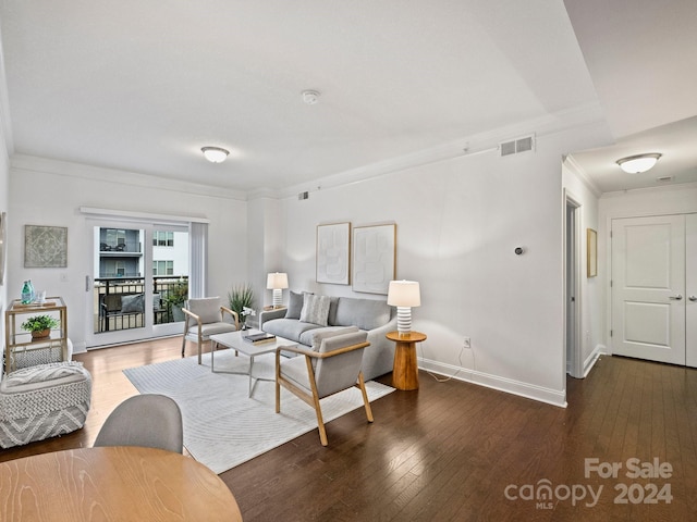 living room featuring dark hardwood / wood-style flooring and ornamental molding