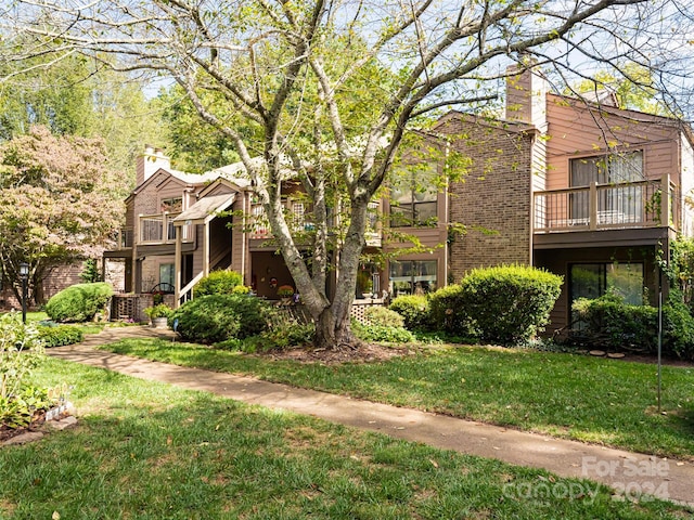 exterior space with a balcony and a front lawn