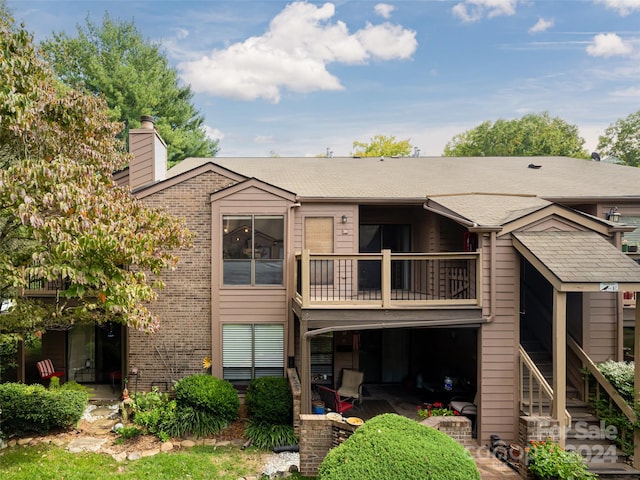 rear view of property featuring a balcony and a patio