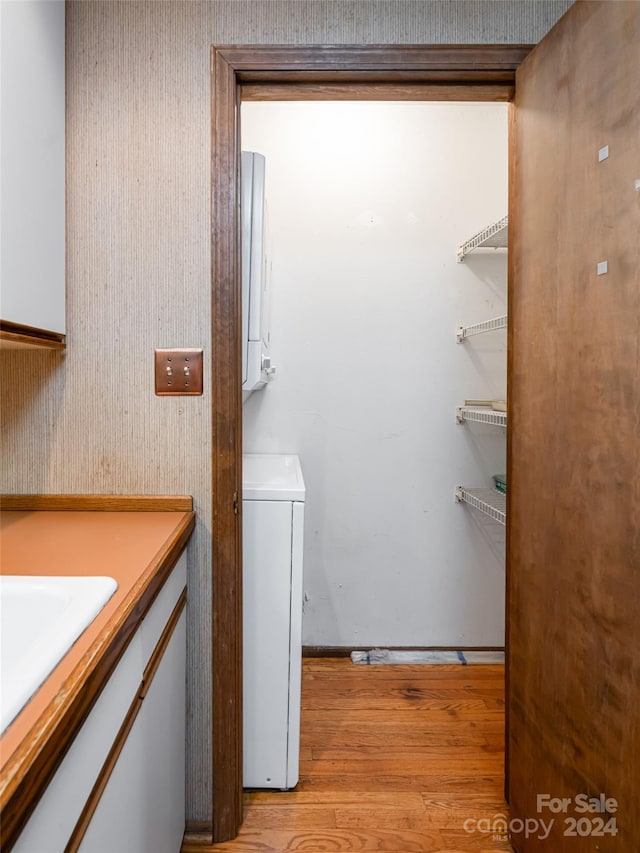 laundry area with light hardwood / wood-style flooring and washer / dryer