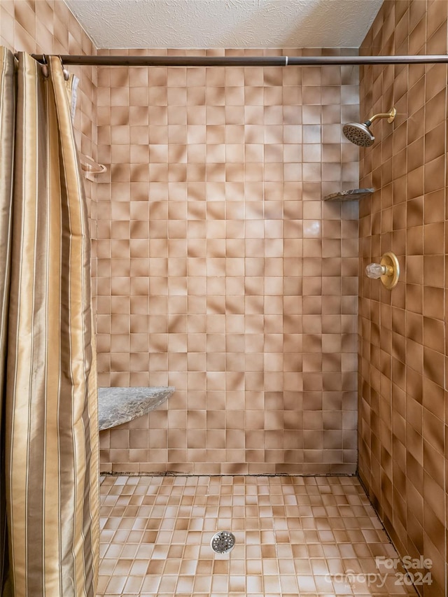 bathroom with walk in shower and a textured ceiling