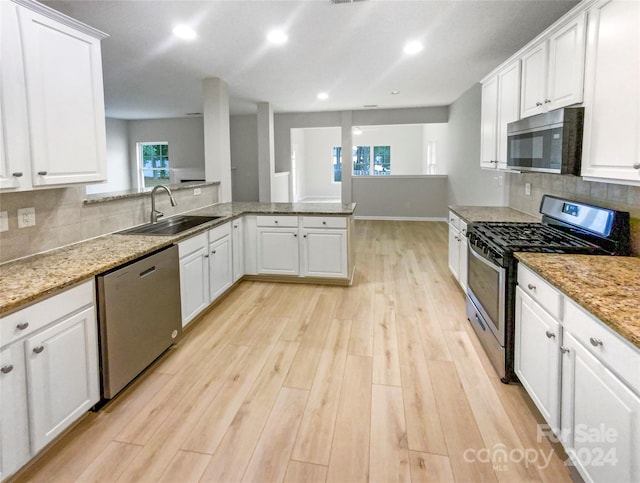 kitchen featuring light wood-type flooring, white cabinetry, appliances with stainless steel finishes, and sink