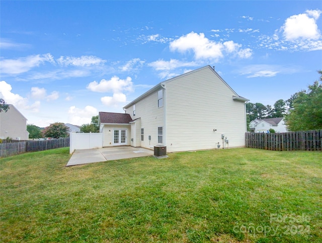 back of property featuring a lawn, cooling unit, and a patio area