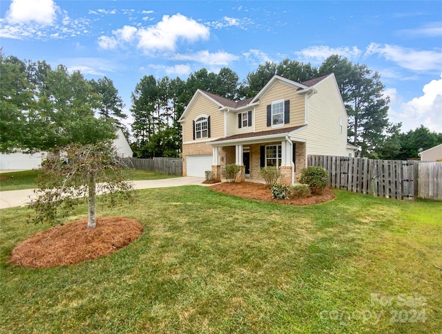 view of property featuring a garage and a front lawn